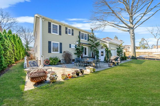 Back of property featuring a patio, a fire pit, fence, and a yard | Image 27