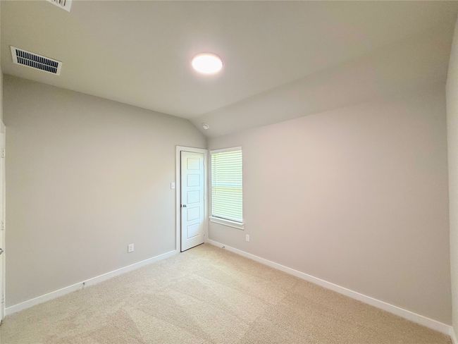 Unfurnished room featuring light carpet and lofted ceiling | Image 22