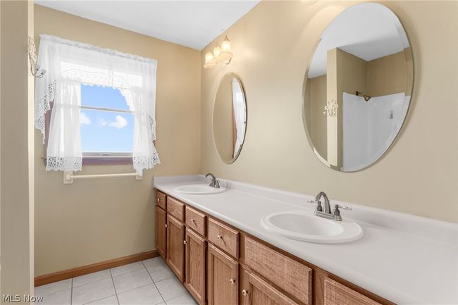 Bathroom featuring tile flooring, oversized vanity, and dual sinks | Image 14