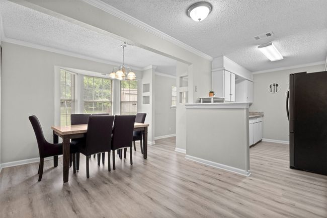 Dining space featuring a textured ceiling, visible vents, an inviting chandelier, and light wood-type flooring | Image 9