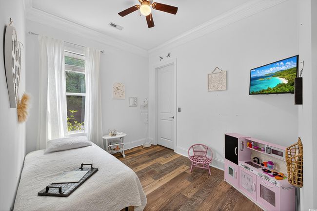 Bedroom featuring crown molding, wood finished floors, and ceiling fan | Image 27