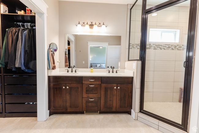 Full bathroom with a stall shower, double vanity, a spacious closet, and tile patterned flooring | Image 24