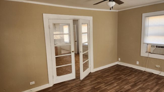 Spare room featuring a ceiling fan, baseboards, dark wood finished floors, and crown molding | Image 6