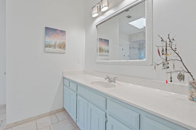 Full bath featuring vanity, tile patterned floors, a shower, and a skylight | Image 20