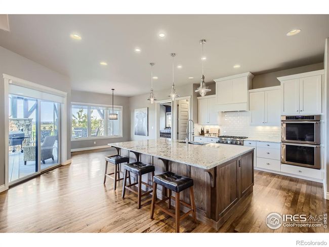 Great room with gas fireplace, hardwood floors, beamed ceiling, fireplace shelving built-ins and surround sound wiring | Image 7