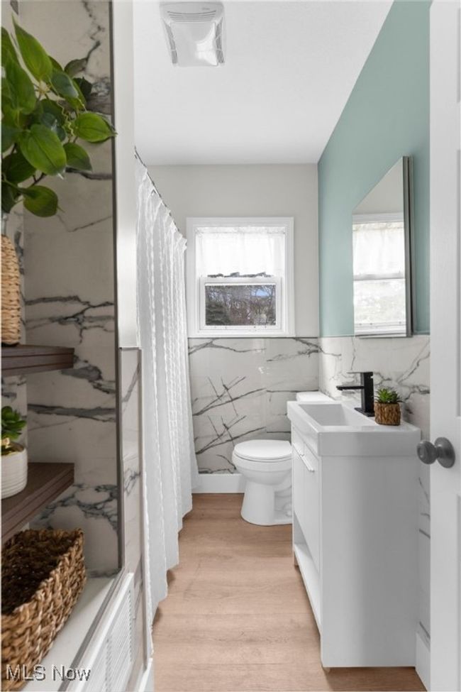 Bathroom with vanity, a wealth of natural light, tile walls, and wood-type flooring | Image 15