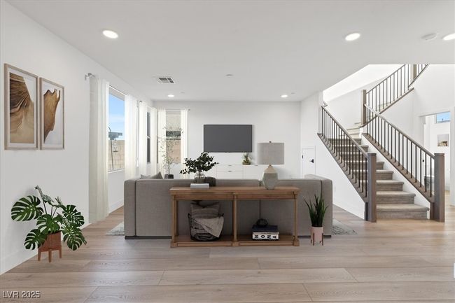 ***Virtually Staged** Living room with recessed lighting, visible vents, stairway, and wood finished floors | Image 9