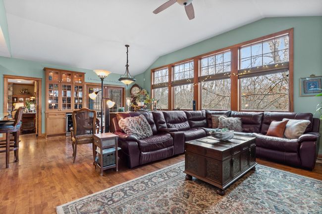 Family room showing view to breakfast area and floor-to-ceiling windows overlooking the back yard. | Image 12