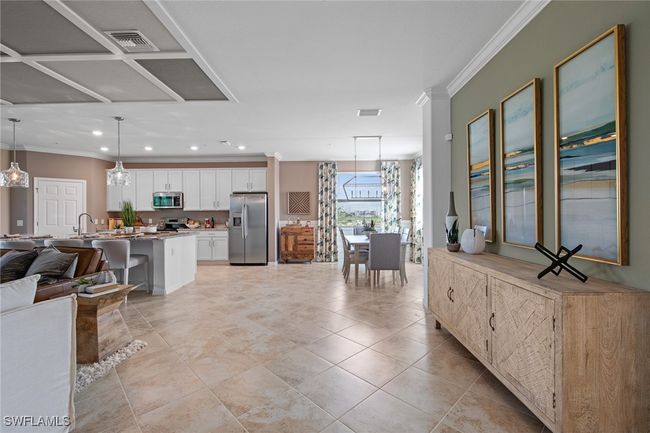 Kitchen featuring visible vents, white cabinets, open floor plan, crown molding, and stainless steel appliances | Image 24