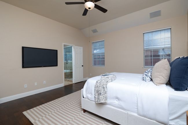 Bedroom with wood finished floors, ensuite bath, vaulted ceiling, and ceiling fan | Image 18