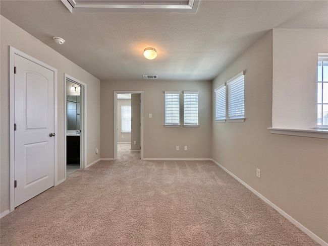 Empty room with a smoke detector, healthy amount of natural light, light carpet, and a textured ceiling | Image 27