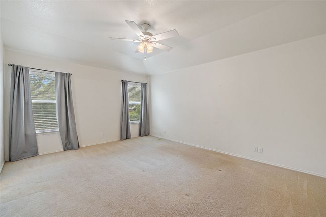 Spare room featuring plenty of natural light, ceiling fan, and light colored carpet | Image 24