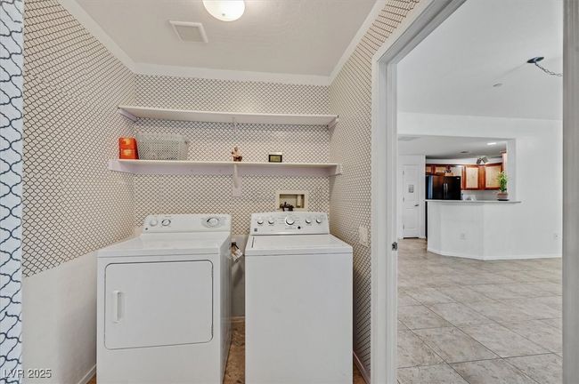Laundry area featuring washer and dryer and light tile patterned floors | Image 19
