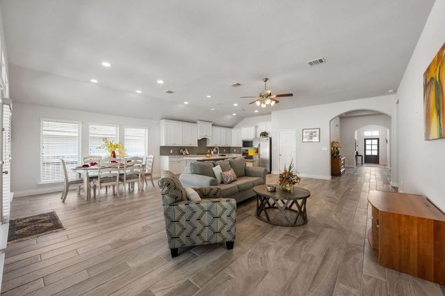Living room featuring recessed lighting, light wood-type flooring, arched walkways, and ceiling fan | Image 13
