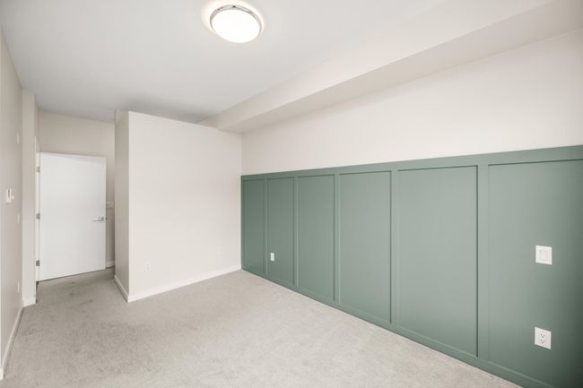 Unfurnished bedroom with a decorative wall and light carpet | Image 23