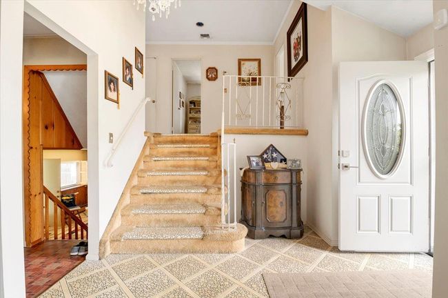 Foyer entrance with stairs, crown molding, and a chandelier | Image 8