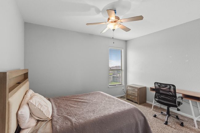 Large secondary bedroom featuring neutral paint, plush carpet, a ceiling fan, and a window with privacy blinds. | Image 16