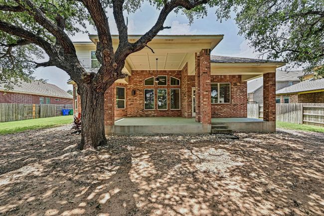 Rear view of house featuring brick siding and covered patio | Image 37