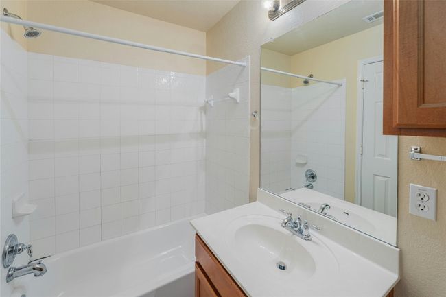 Full bath with shower / bath combination, vanity, and a textured wall | Image 23