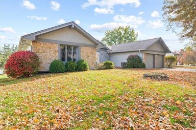 Ranch-style home featuring a front yard and a garage | Image 2