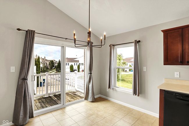 unfurnished dining area with a chandelier, lofted ceiling, plenty of natural light, and light tile floors | Image 17