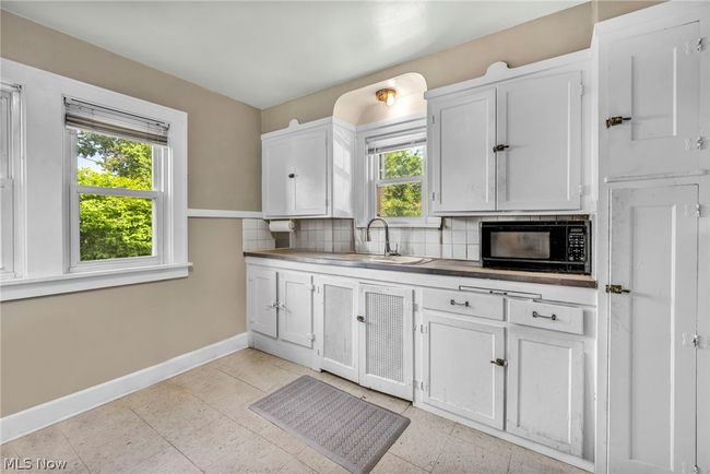 Kitchen featuring sink, a wealth of natural light, tasteful backsplash, and light tile floors | Image 8