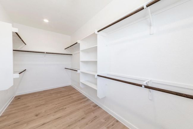 Spacious closet featuring light wood-style flooring | Image 14