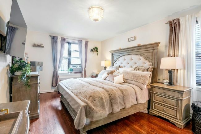 Bedroom with dark wood-style floors and baseboards | Image 12