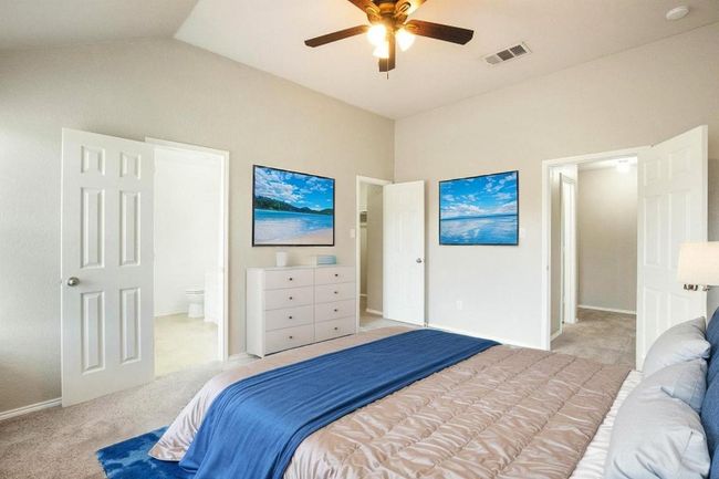 Bedroom featuring carpet, connected bathroom, vaulted ceiling, and a ceiling fan | Image 14