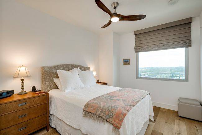Bedroom with light wood finished floors and a ceiling fan | Image 13