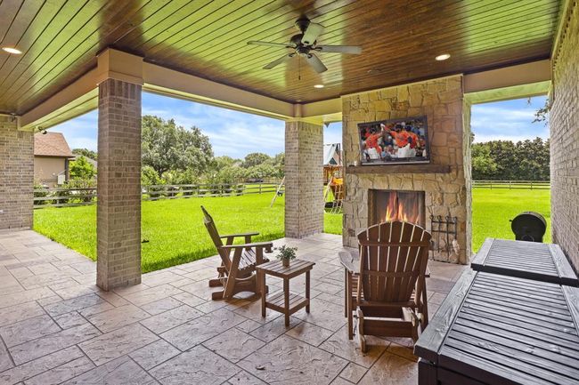 Cozy up by this floor to ceiling stone fireplace. The custom wood mantle matches the one found inside, and acts as a great place to display your TV. Add cozy couches, gliders, or a table and chairs, because this is where you will want to spend your lazy evenings. | Image 42