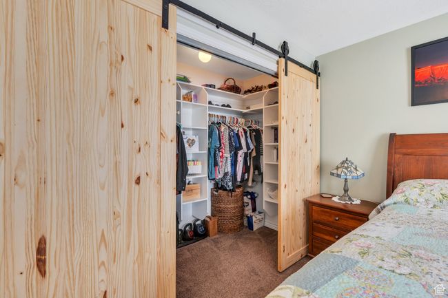 Bedroom with carpet, a barn door, a spacious closet, and a closet | Image 9