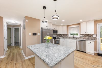 Kitchen with a center island, appliances with stainless steel finishes, and white cabinetry | Image 2