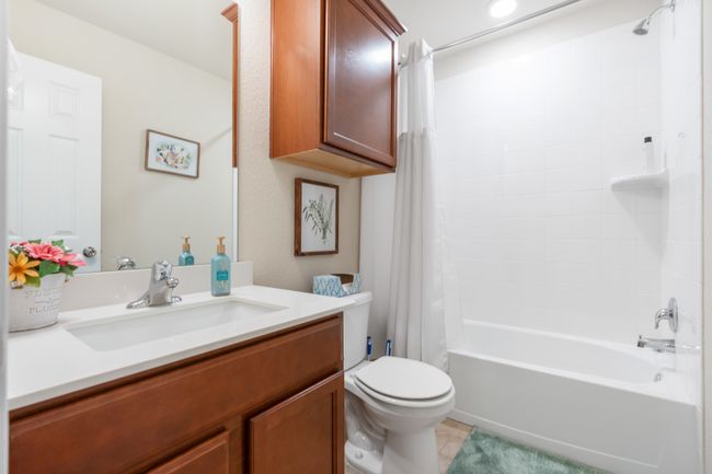 Bathroom featuring toilet, vanity, shower / tub combo, and tile patterned floors | Image 11