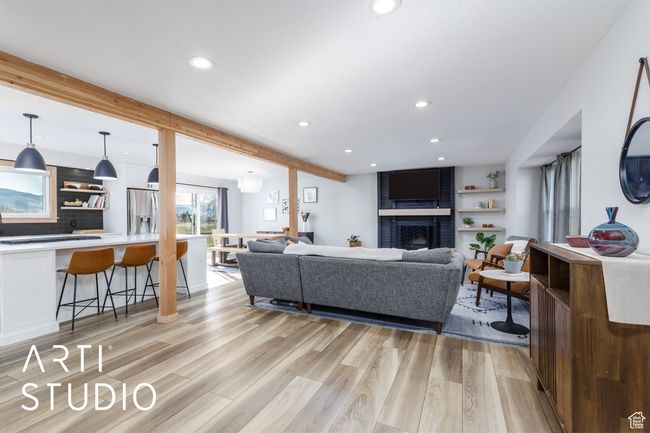 Living area featuring light wood finished floors, a fireplace, recessed lighting, and beamed ceiling | Image 6