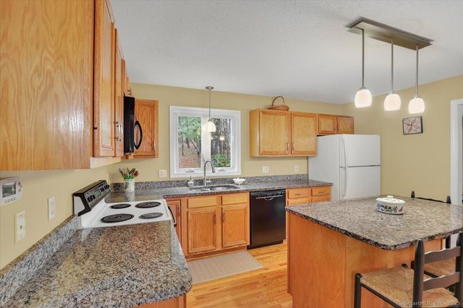 Granite counters, hardwood floors, island with seating for four | Image 5