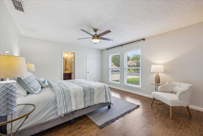 Bedroom with wood finished floors, a textured ceiling, ensuite bath, and ceiling fan | Image 15