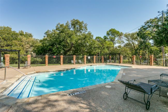 Community pool featuring a patio and view of wooded area | Image 25
