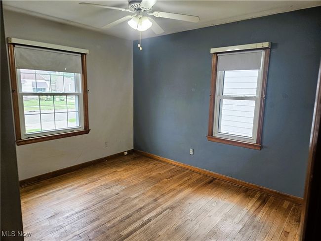 Empty room featuring hardwood / wood-style floors, a ceiling fan, and baseboards | Image 6