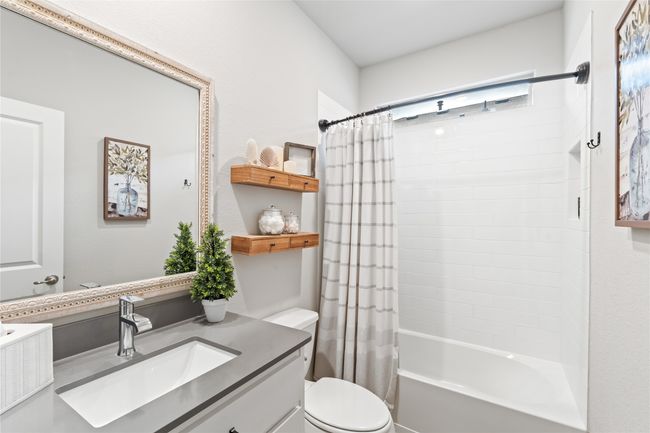Bathroom featuring vanity, toilet, and shower / tub combo with curtain | Image 23