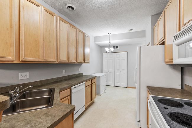 Spacious kitchen with maple cabinetry. There's space for an informal dining table. | Image 6