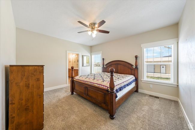 Bedroom with multiple windows, a ceiling fan, baseboards, and light carpet | Image 20