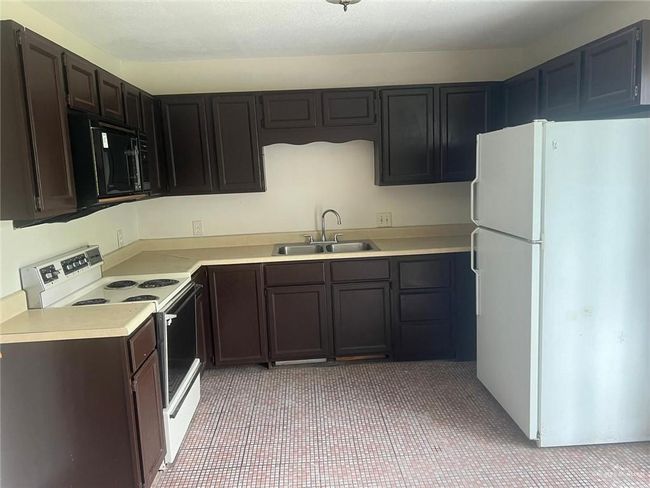 Kitchen featuring white appliances and light countertops | Image 13
