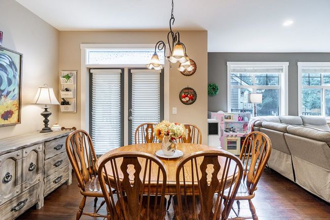Dining area with dark wood-style flooring and a chandelier | Image 11