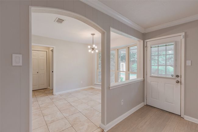 Foyer entrance featuring crown molding, a chandelier, and arched walkways | Image 15