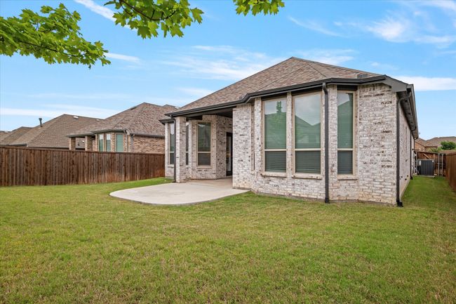 Back of house featuring a patio, a fenced backyard, a lawn, and brick siding | Image 16