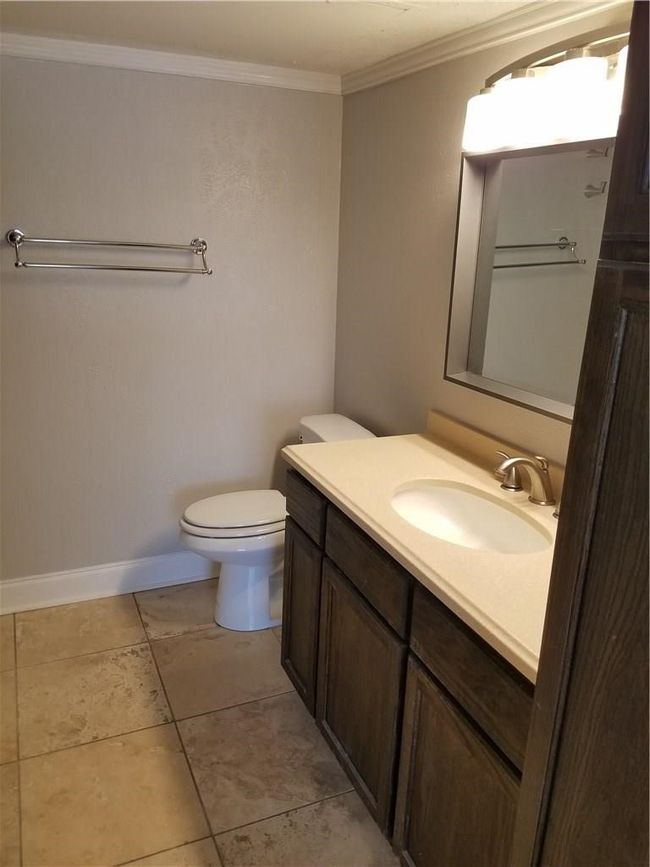 Bathroom featuring vanity, crown molding, toilet, and baseboards | Image 8