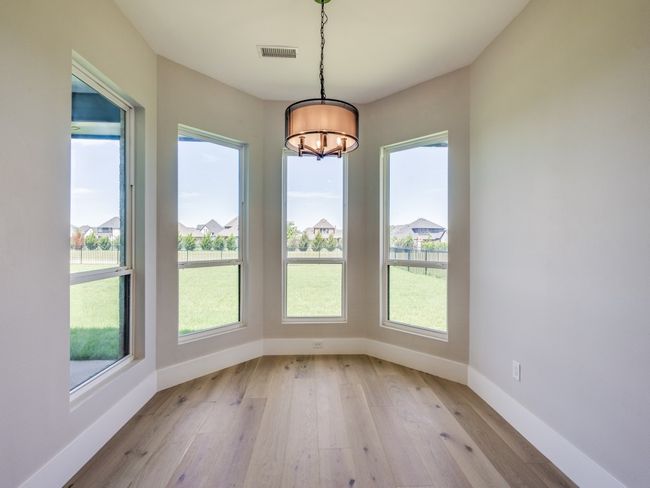 Unffurnished Breakfast room dining area with a chandelier, light wood finished floors, and lovely windows to let in plenty of light | Image 21