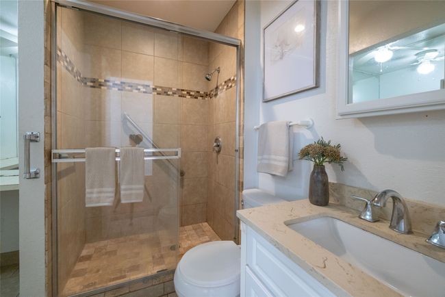 Full bathroom with toilet, a shower stall, and vanity | Image 10