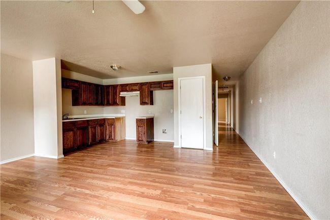 Unfurnished living room featuring light wood finished floors and a textured ceiling | Image 4